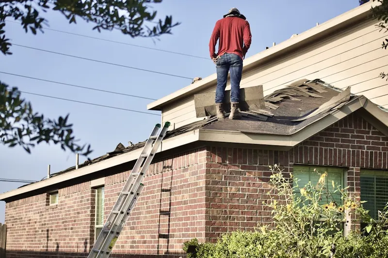 Professional roofer working on a residential roof in Dean